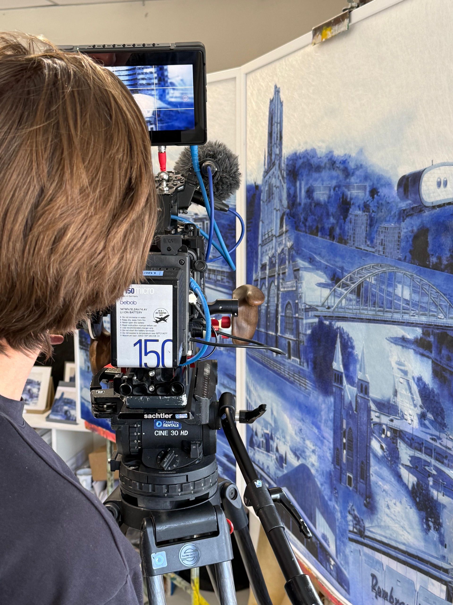Een filmcamera gericht op een Arnhemse Iconen-werk in het atelier.