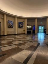 Two blue and gold planetary paintings in the round marble foyer of the planetarium.