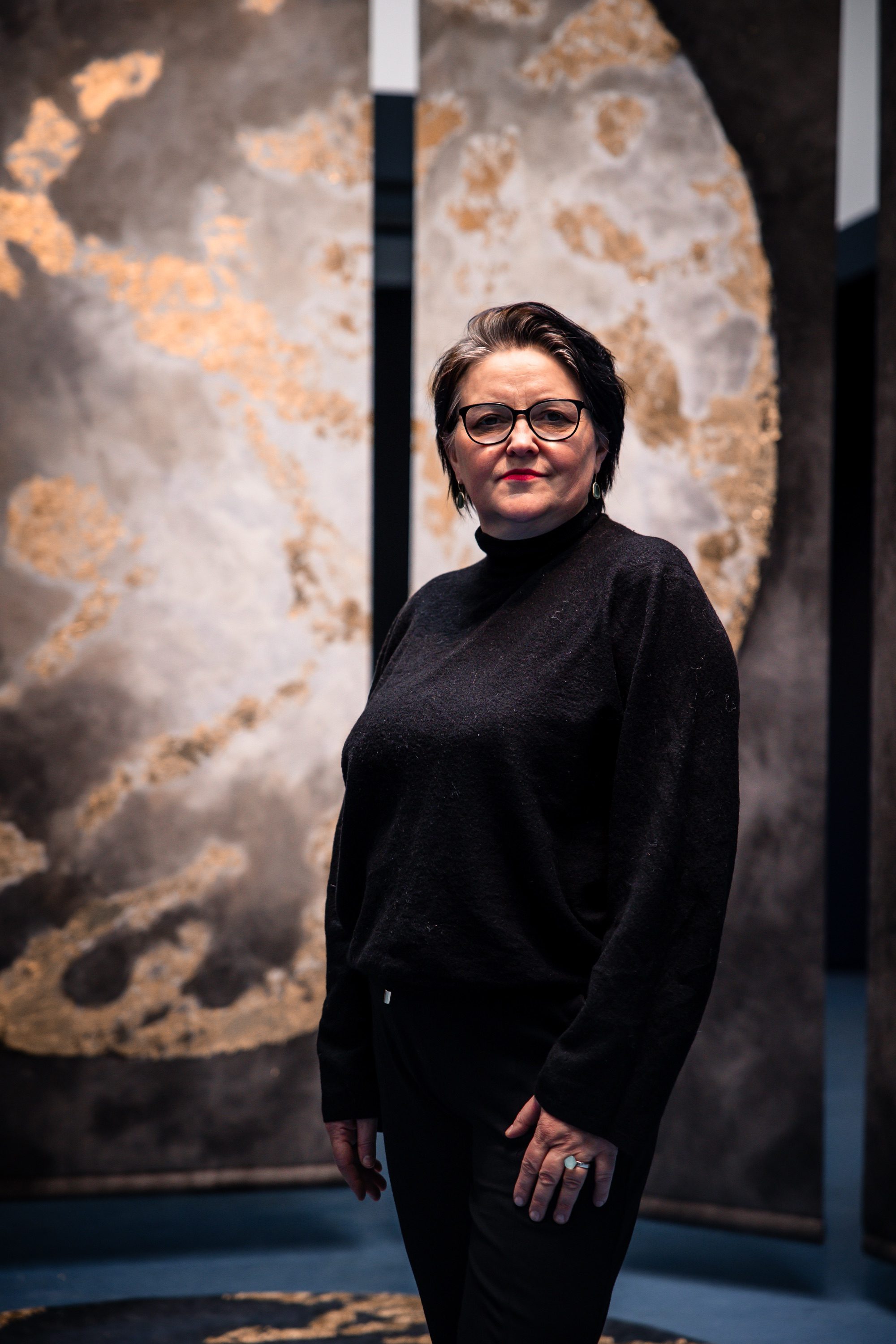 Portrait of the artist in front of two panels of Connected.