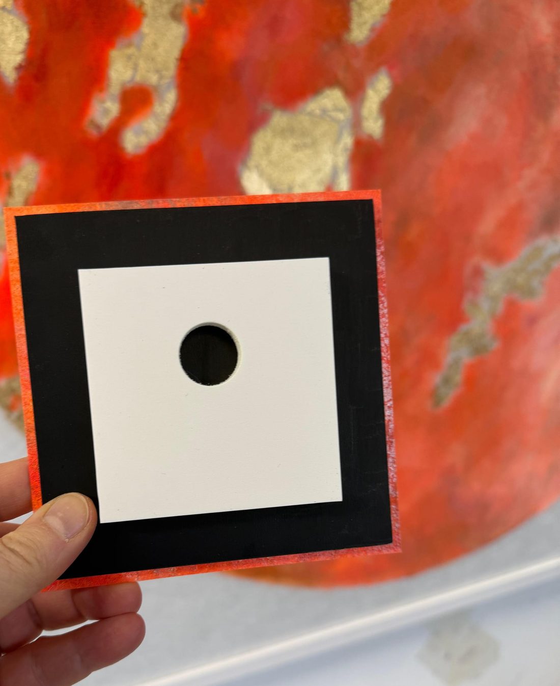 The back of the work: a black backing board with a white mounting block and keyhole.