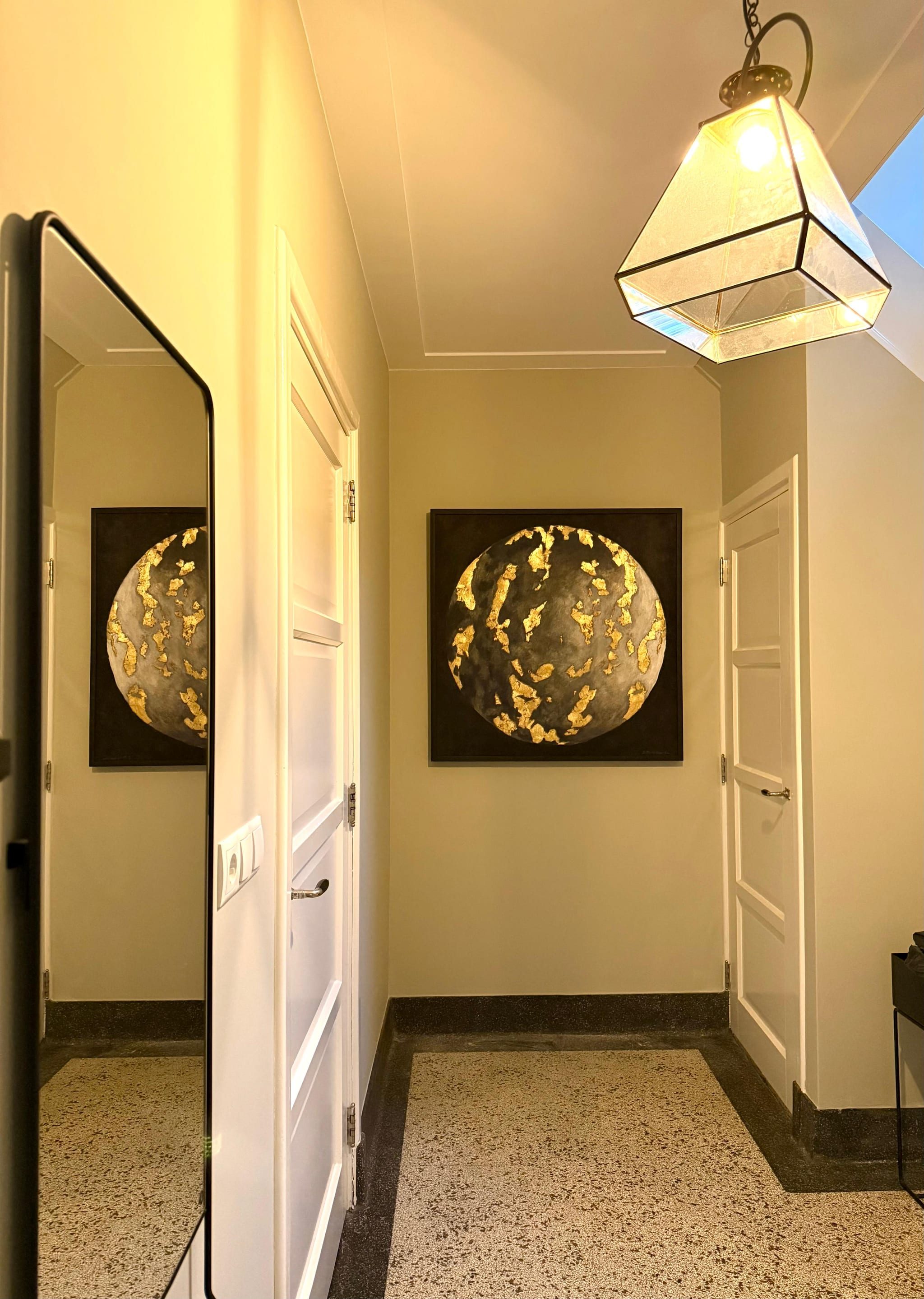 The hallway with a full-length mirror on the left, in which the work opposite appears a second time, beneath an art deco lantern.