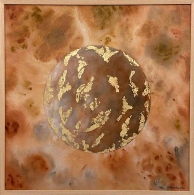 A brown planet with islands of gold-coloured metal leaf against an ochre and rust sky, in a light wooden frame.