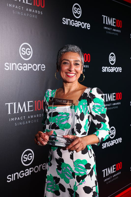 Zainab Salbi holding the TIME100 Impact Award trophy at the ceremony in Singapore, 2023