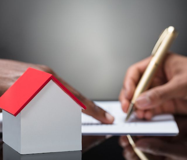 Signing VA loan documents with a house concept in table