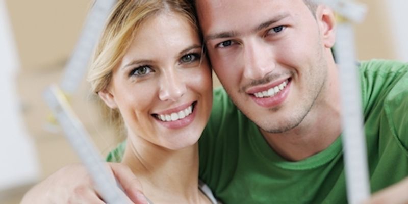 Couple holding a house model.