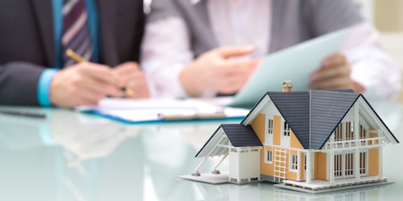 Signing VA loan offer with a house concept in table.
