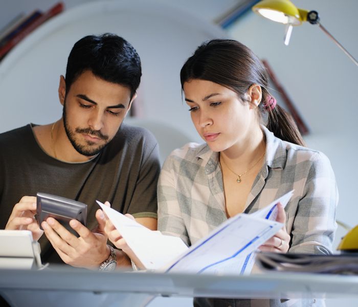 Couple calculating interest rate of home mortgage.