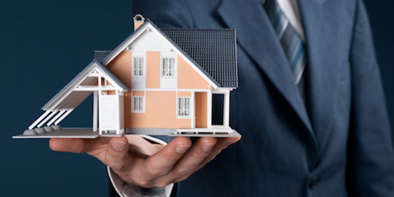 Man holding a miniature house.