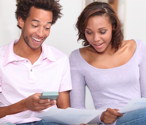 Couple holding documents and calculating title insurance