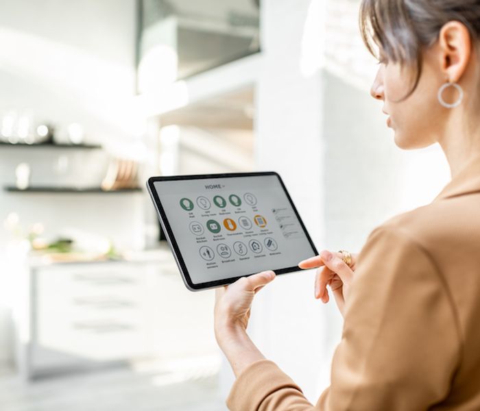 Woman controlling smart home using a gadget.