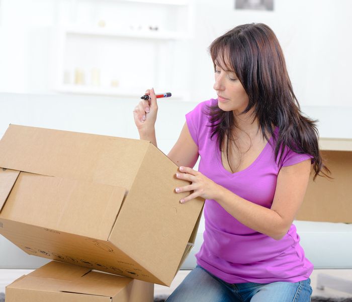 Woman labeling boxes for moving.