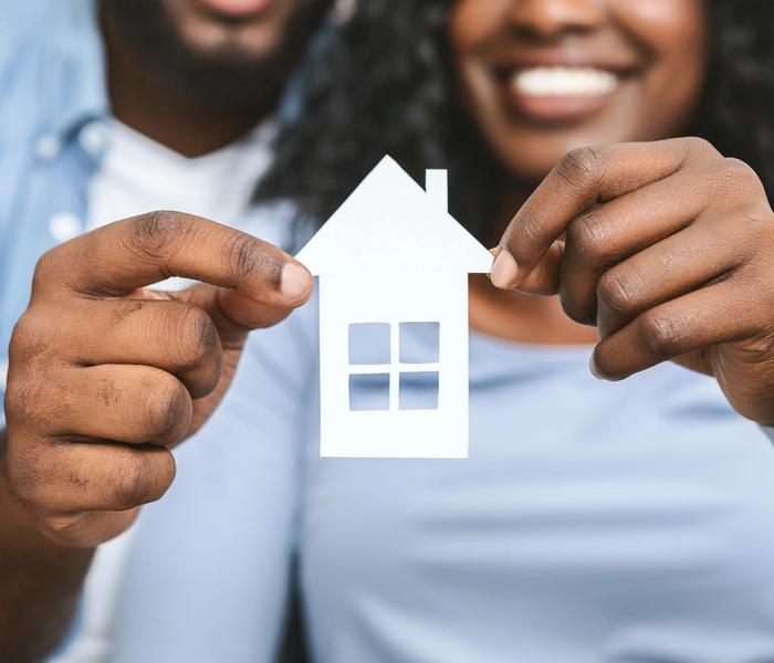 Couple holding house illustration.