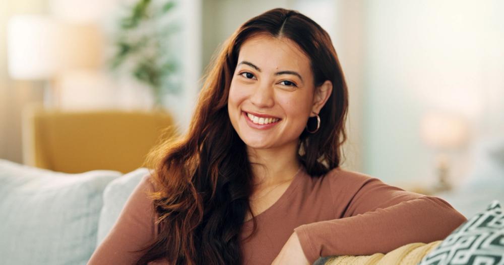 A woman sitting on a sofa at home.