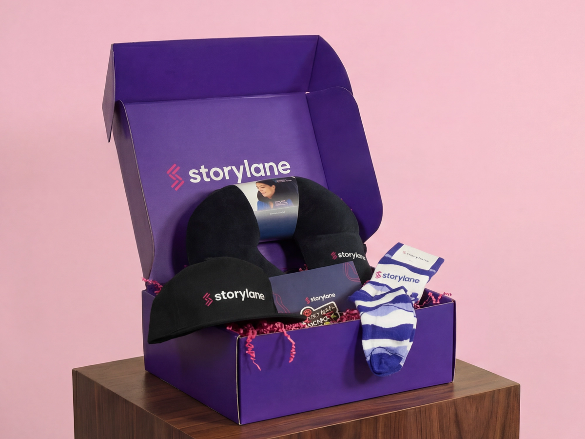 Storylane custom swag box with branded baseball cap, travel pillow, socks, and stickers in a purple branded shipping box.