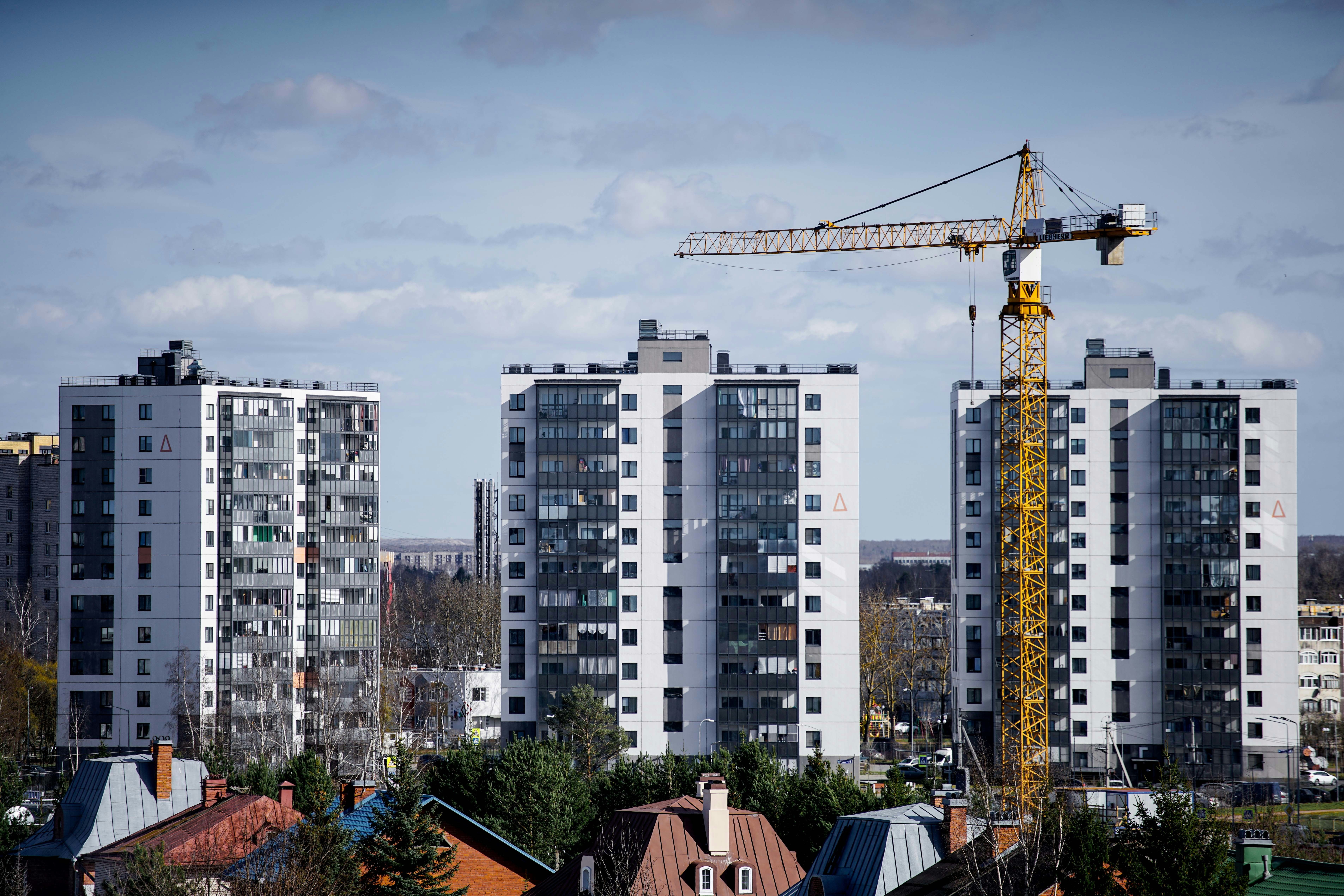 Жилищни сгради в строеж с кулокран, илюстриращи приложението на DPP регулациите в строителството.