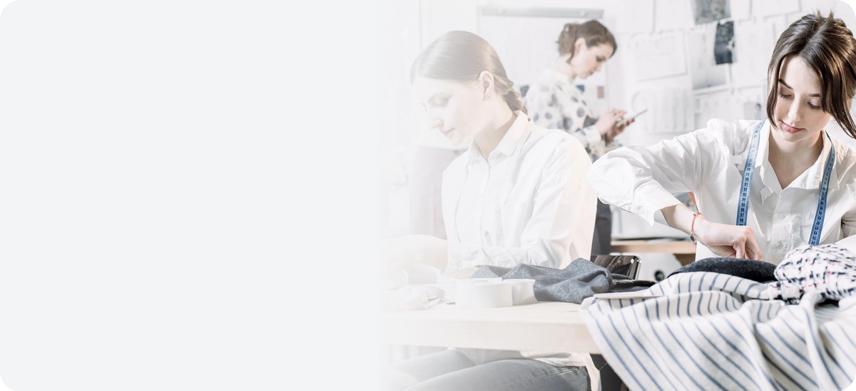 Tailors and designers working on clothes in a studio – illustration of the textile industry and the introduction of Digital Product Passport.
