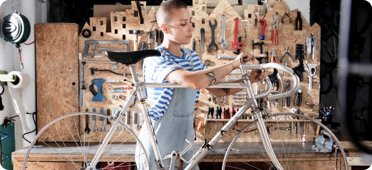 Майстор ремонтира велосипед в работилница с инструменти