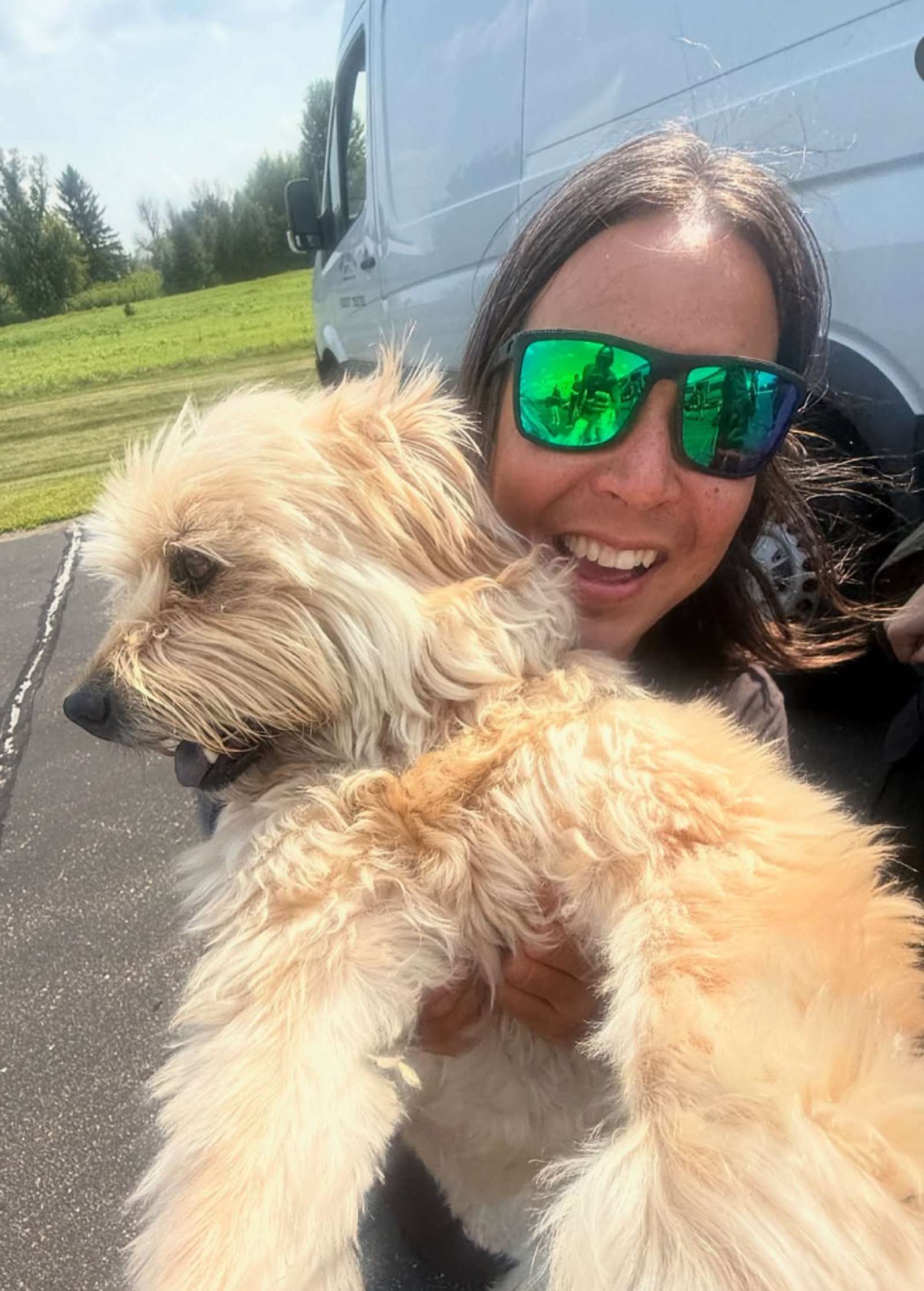 Guy with reflective sunglasses and his white dog.