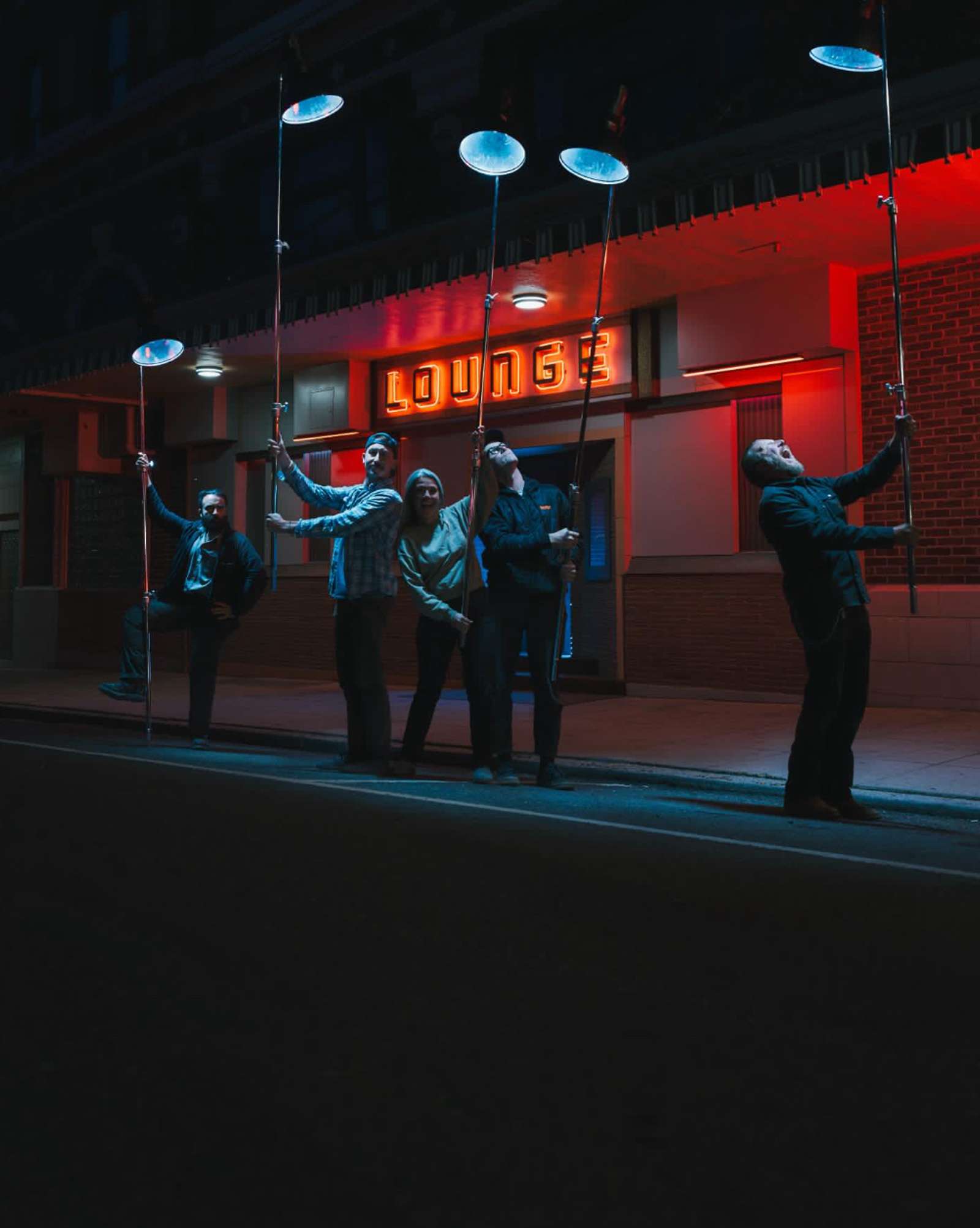a man and a woman are sitting in the back of a car holding a camera .