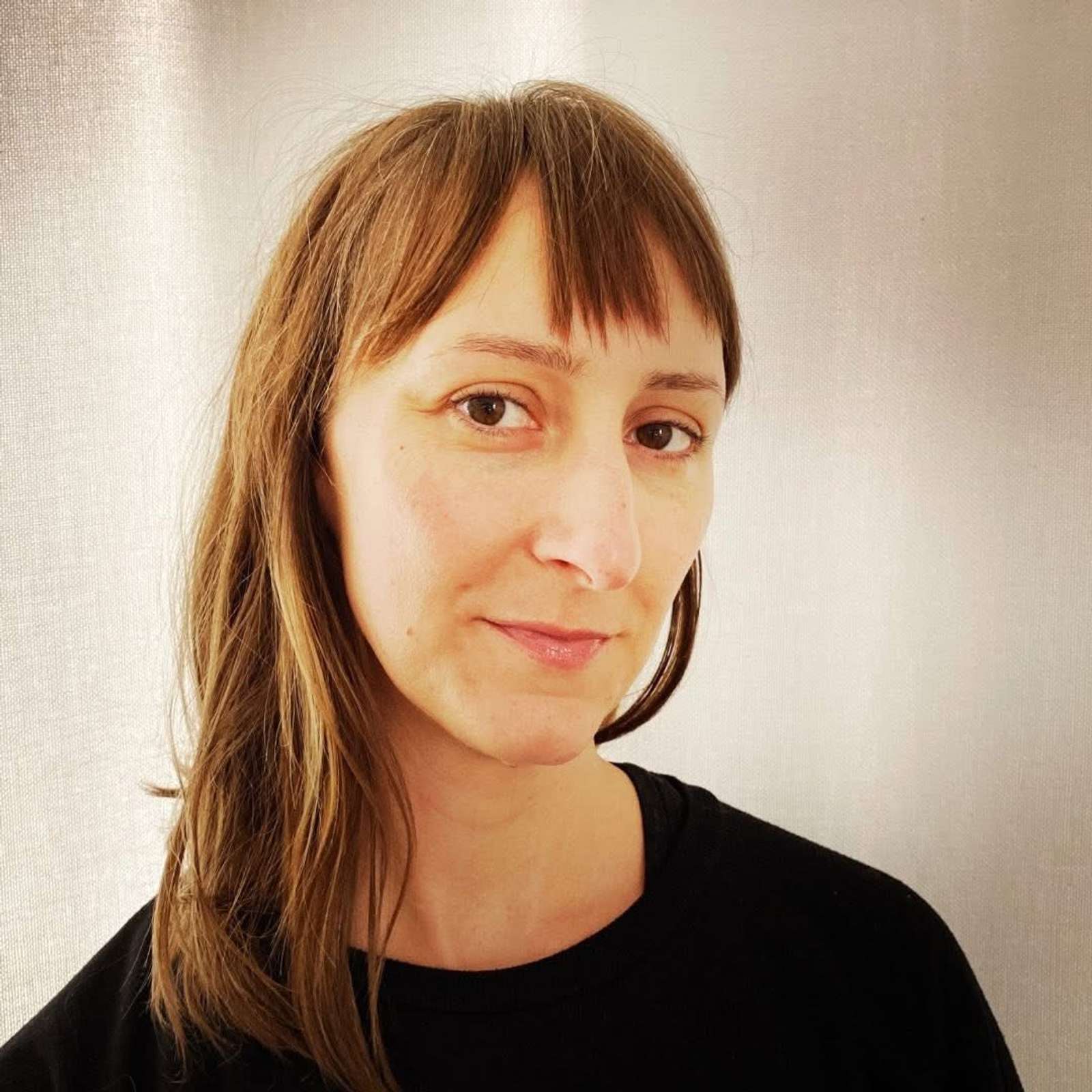 Woman standing by the road in glacier national park with a safety vest on