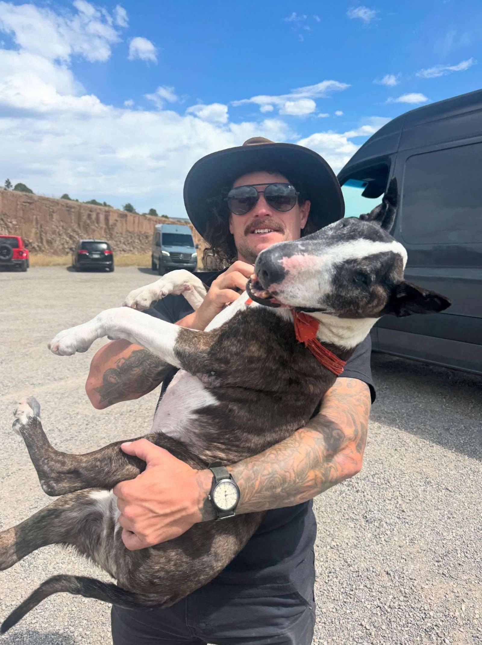 Guy in hat holding a bull terrier