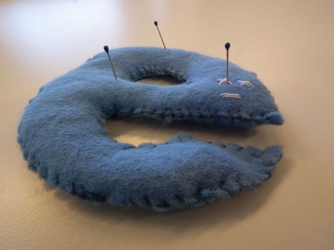 An Internet Explorer logo pin cushion with pins sticking out