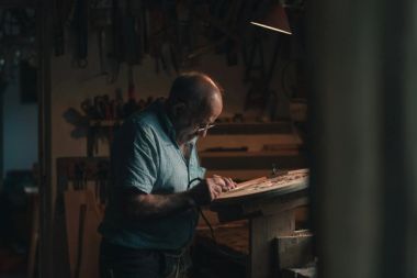 a man in a workshop carving wood