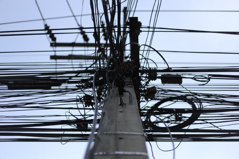 a tangled mess of wires on a power pole