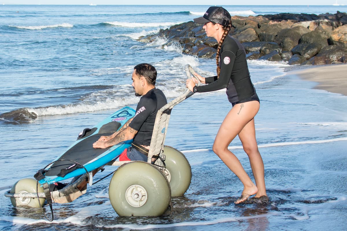 Gammie Homecare customer using a beach wheelchair for surfing