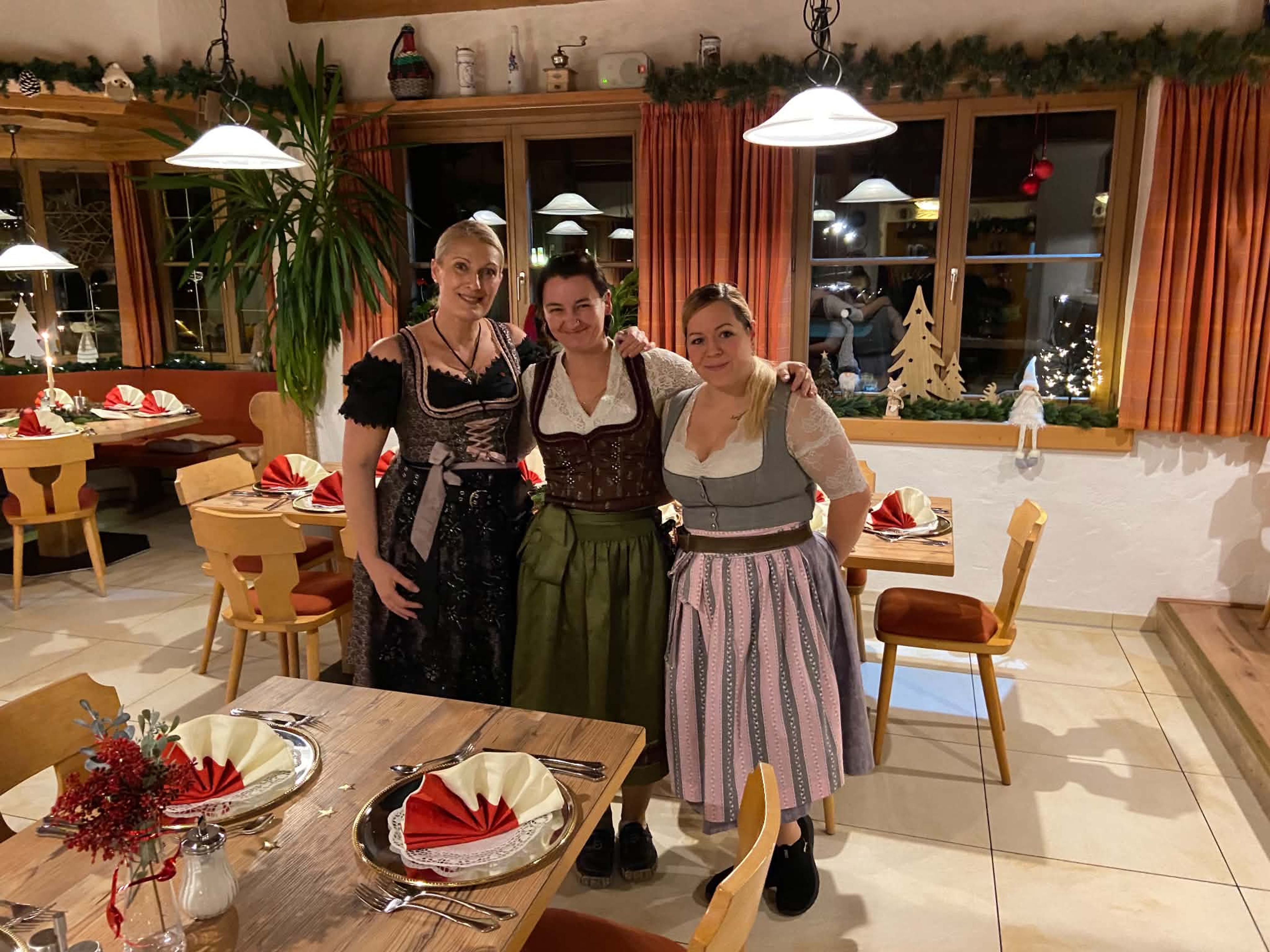 Drei Mitarbeiterinnen im Dirndl in der weihnachtlich geschmückten Gaststube