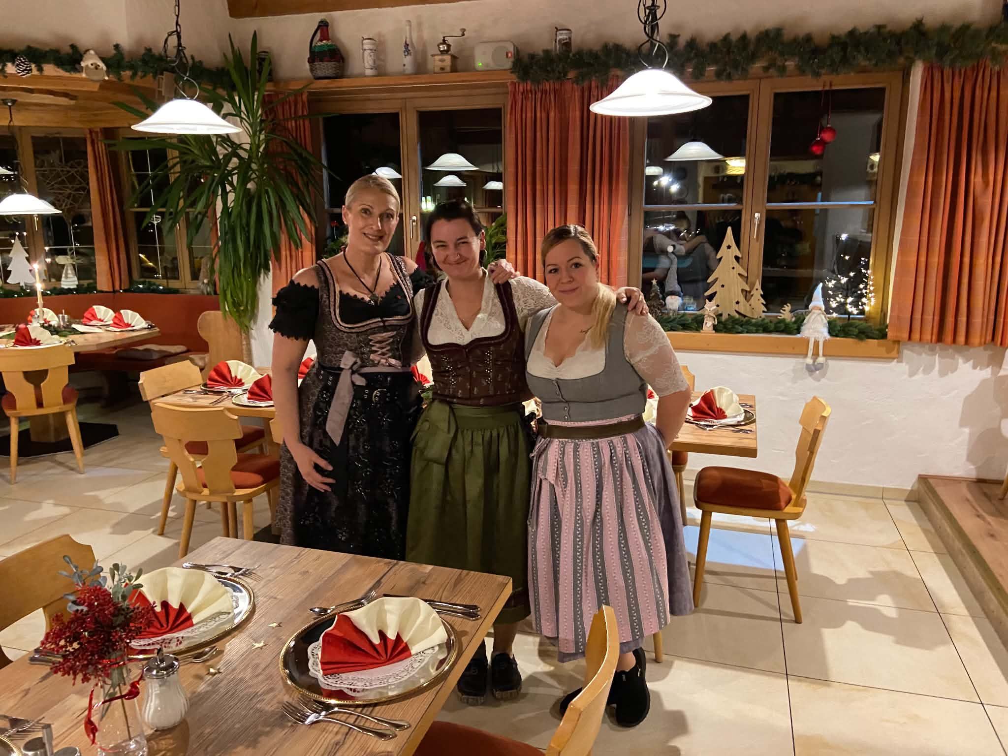 Drei Mitarbeiterinnen im Dirndl in der weihnachtlich geschmückten Gaststube
