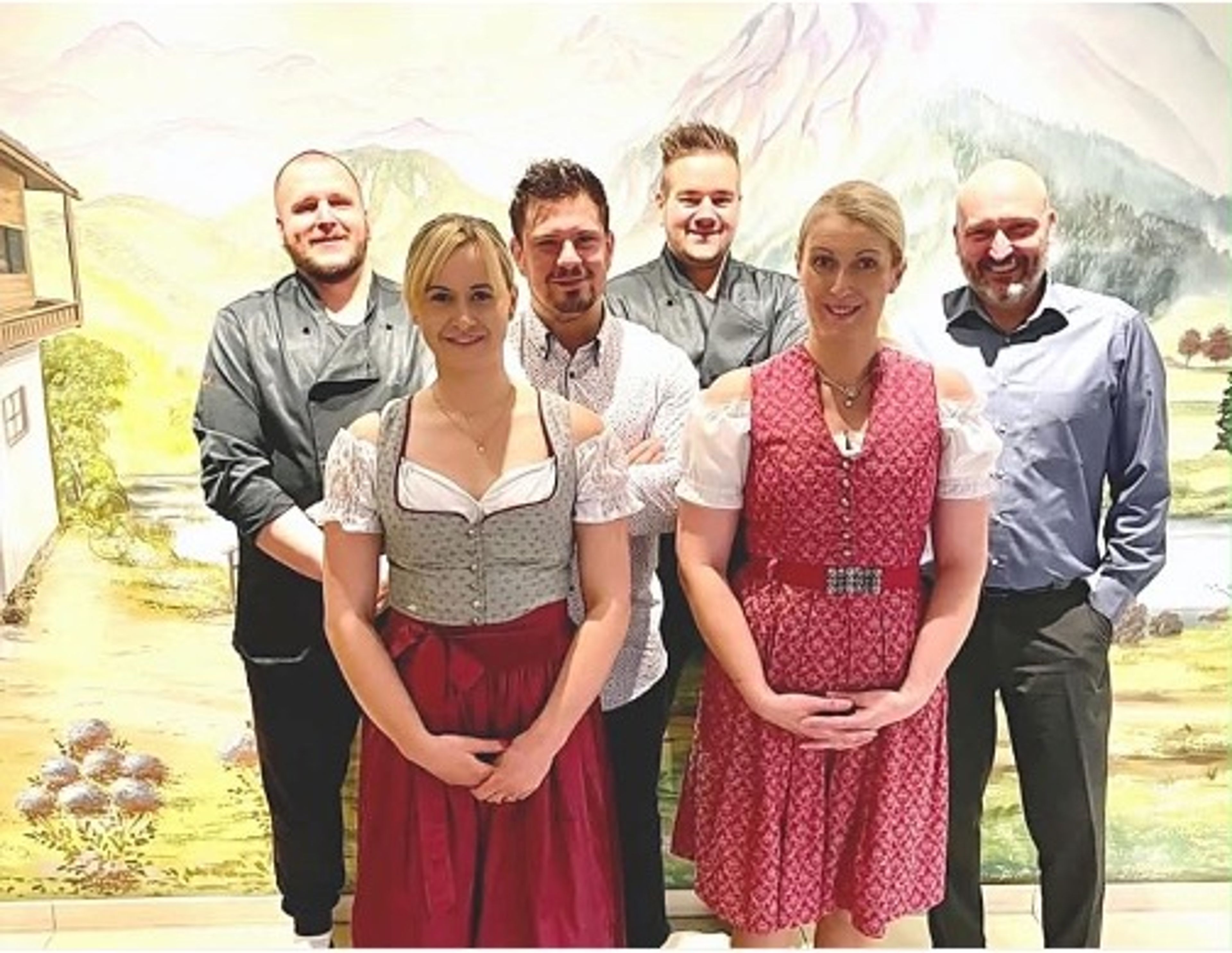 Das Team des Alpstuben vor einem gemalten Alpenpanorama