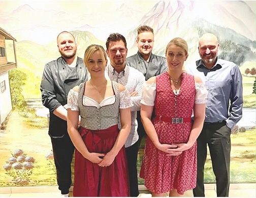 Das Team des Alpstuben vor einem gemalten Alpenpanorama