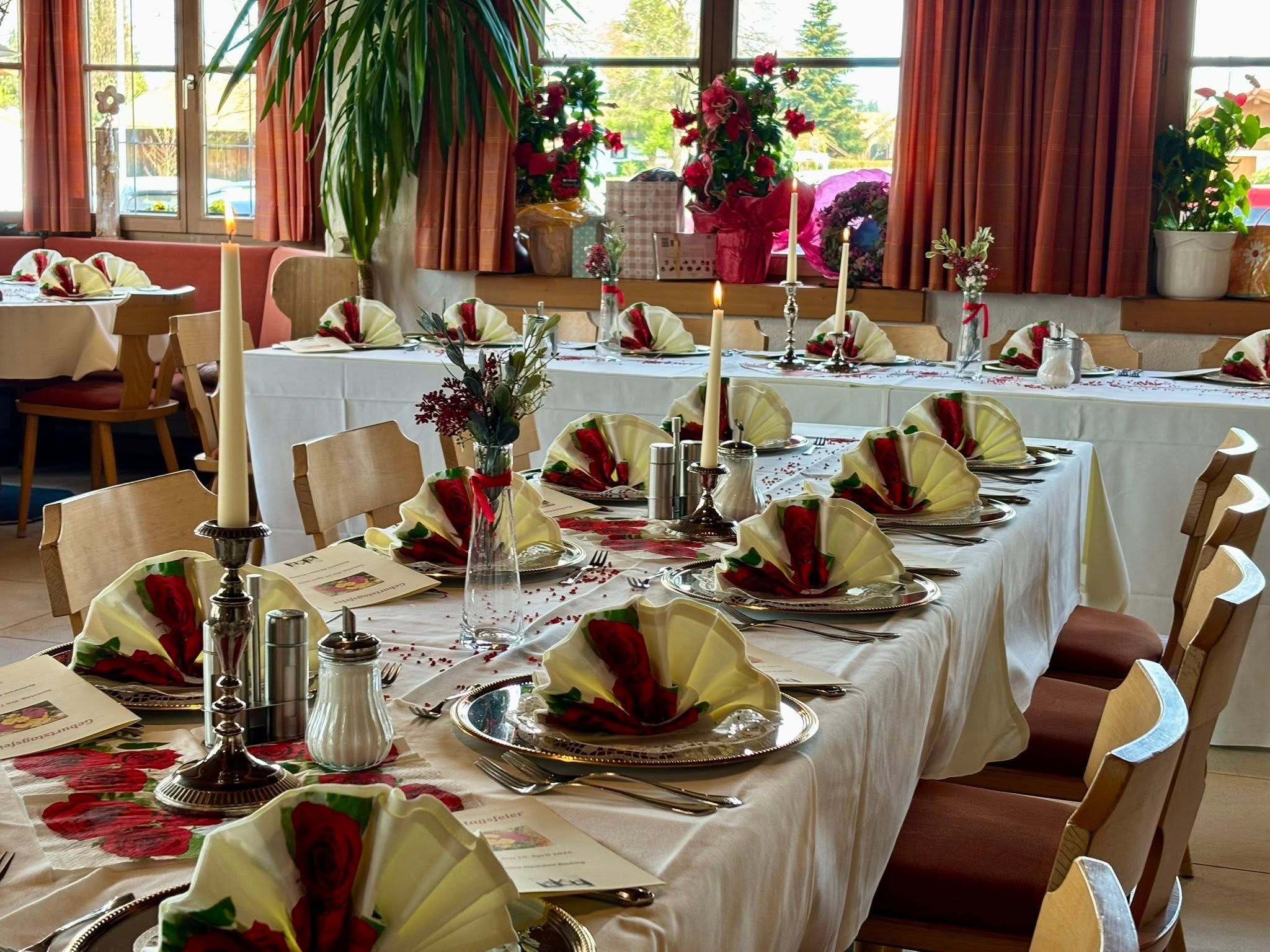 Festlich gedeckte Tafel mit Rosenservietten, Kerzen und Blumen zu einer Geburtstagsfeier