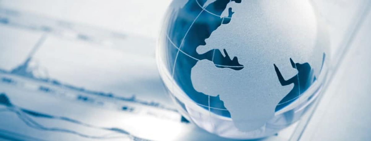 Silver and blue globe of the world placed on a foreign exchange chart.