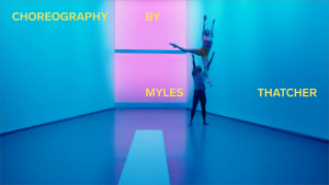 Two people dancing in a room lit with blue light overlayed with the text "CHOREOGRAPHY BY MYLES THATCHER"