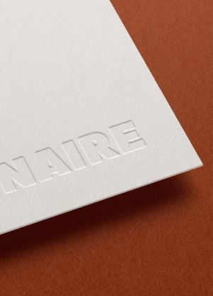 The Resonnaire logo debossed into white cardstock on a brown background