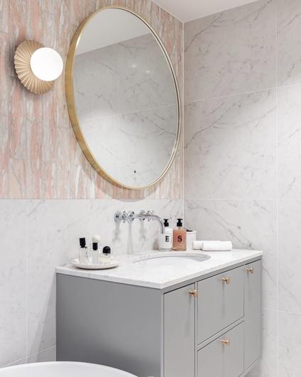 Eksklusivt, klassisk bad i lyse, delikate fargetoner. Badet er flislagt med norsk, rosa Fauske marmor. Baderomsinnredning i gråtoner med benkeplate i Carrara marmor. Utført av Lomundal.
