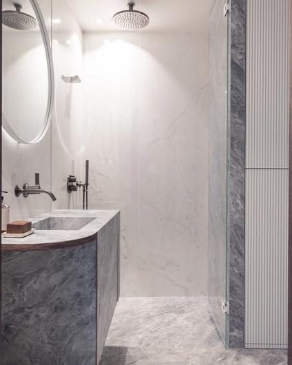 Sømløst, lite bad med skreddersydde baderomsmøbler tilpasset rommet. Badet har unike løsninger og detaljer som løfter det eksklusive uttrykket i rommet. Utført av Lomundal.