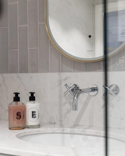 Moderne bad i gråtoner. Badet har et stilrent uttrykk med Carrara og blanke fliser på vegg. Utført av Lomundal.
