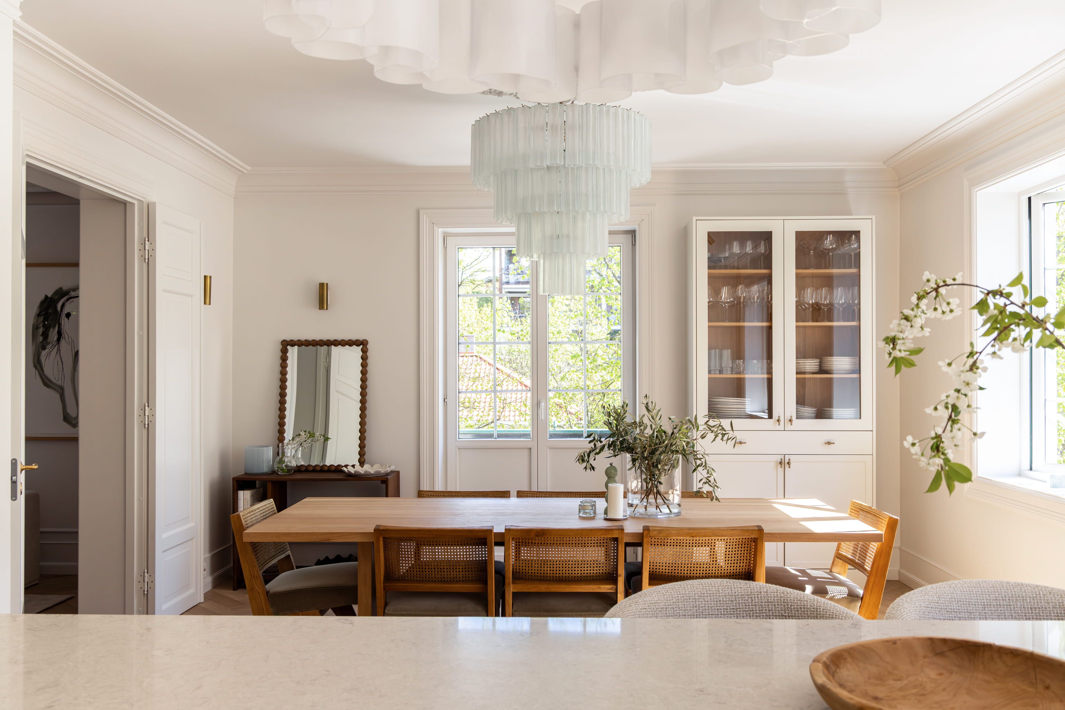 Et lyst kjøkken og spisestue i klassisk stil, med elegante detaljer og et tidløst uttrykk som passer bygården. Utført av Lomundal.