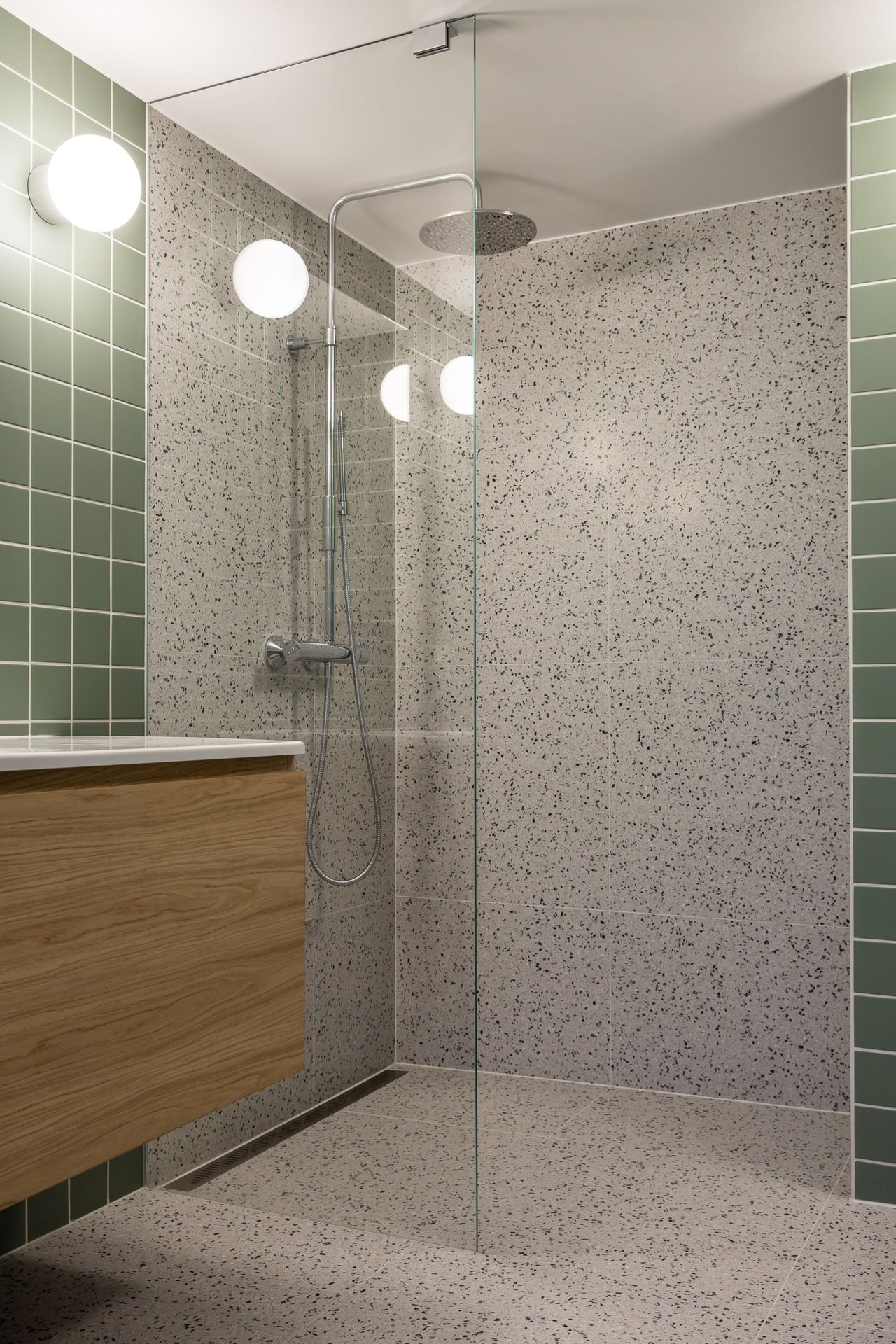 Retro bad med grønne fliser på vegg, terrazzo på gulv og dusjrom, med møblement i eik finer, utført av Lomundal. - Bilde