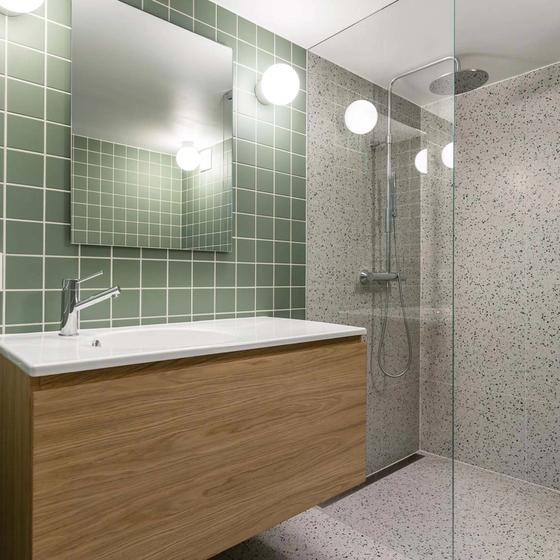 Retro bad med grønne fliser på vegg, terrazzo på gulv og dusjrom, med møblement i eik finer, utført av Lomundal.