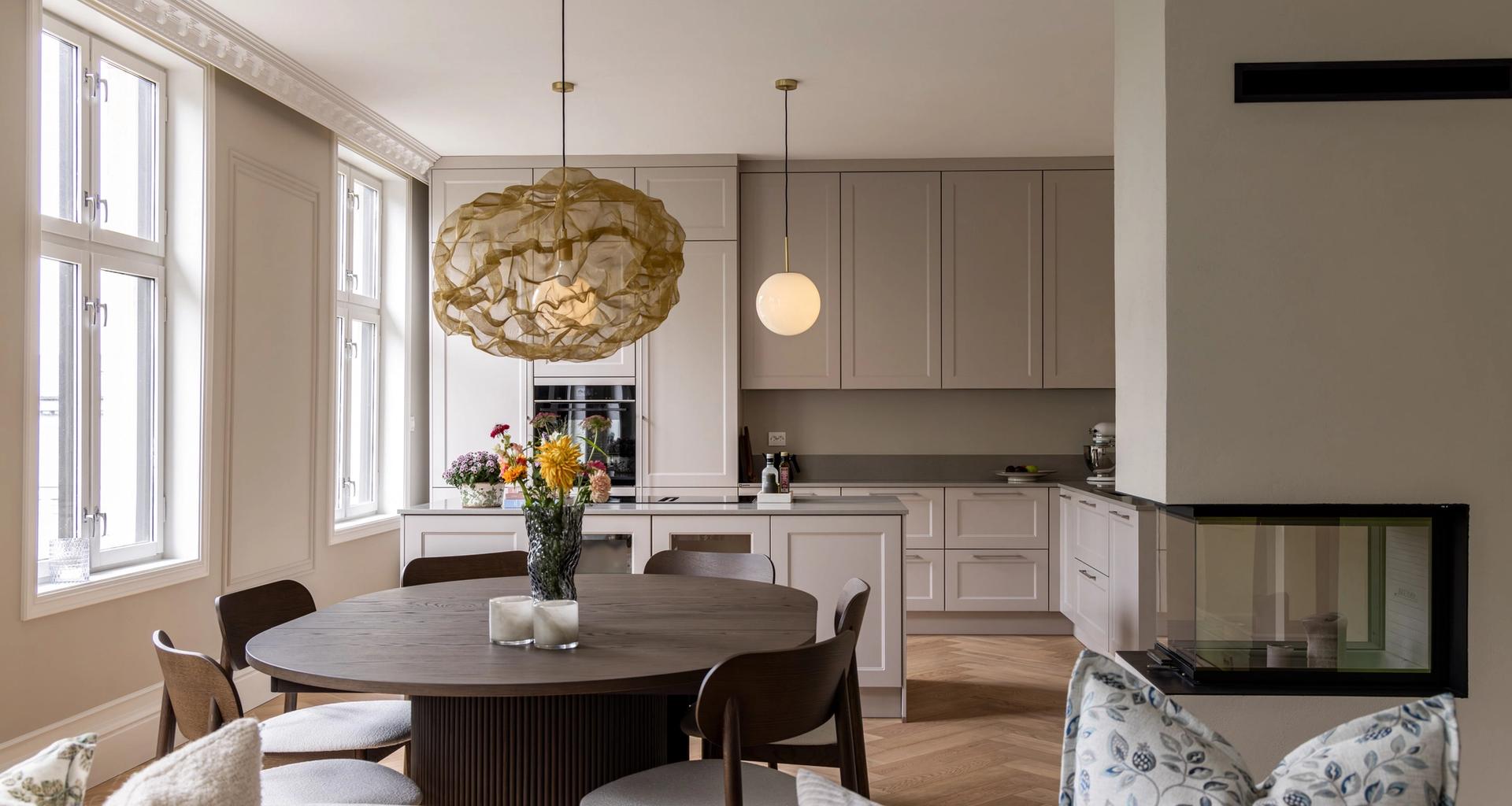 Åpen stue og kjøkkenløsning i klassisk leilighet på Grunerløkka. Vegger og innredning i beige toner. Leiligheten er totalrenovert av Lomundal.