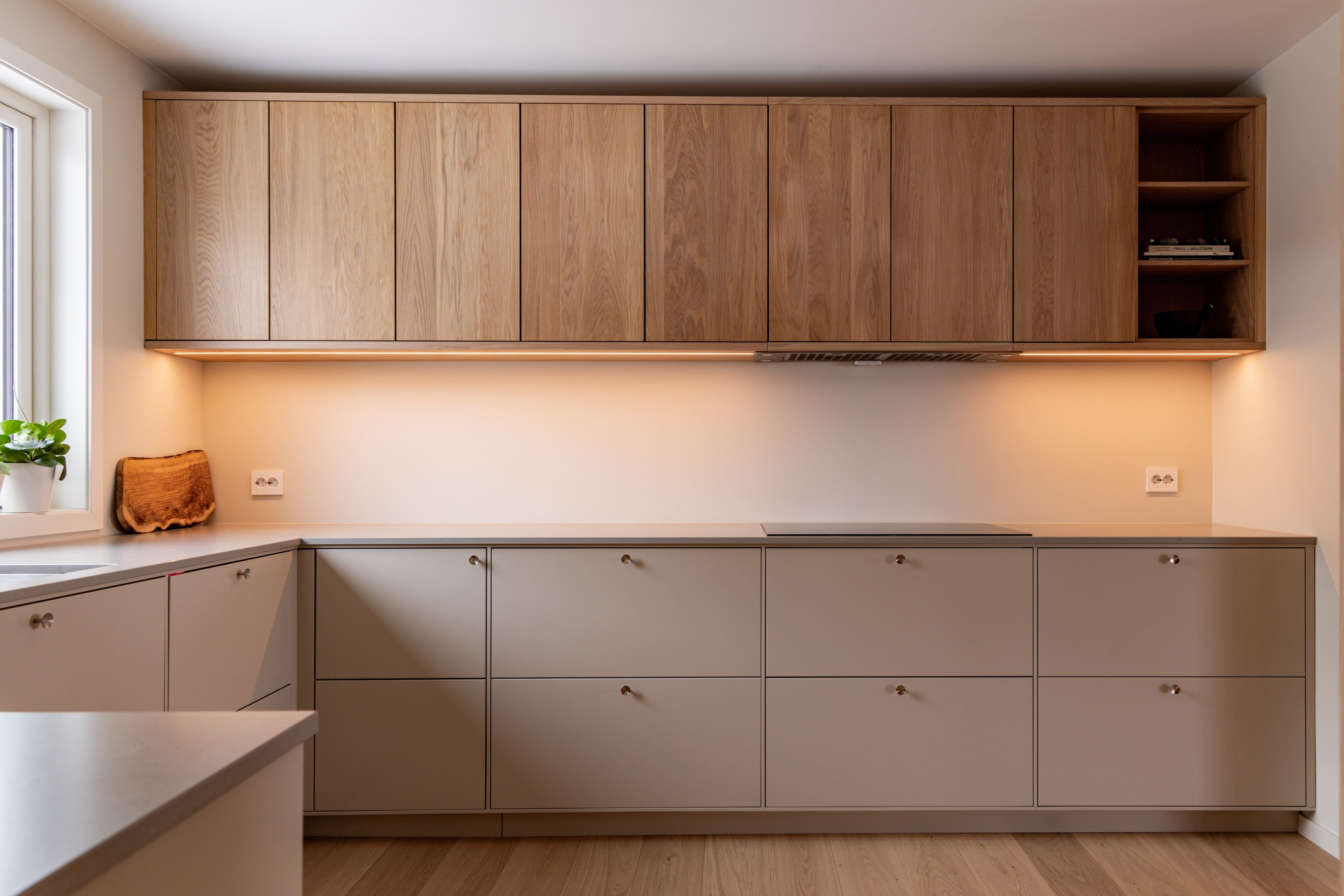 Et elegant kjøkken i skandinavisk stil. LED-liste under overskap gjør kjøkkenet svært visuelt tiltalende. Dette kjøkkenet gir en følelse av varme og velvære.