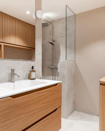 Bad som kombinerer fliser og malte overflater med baderomsinnredning i eik.