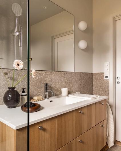Et skandinavisk bad med organisk uttrykk som kombinerer malte flater og terrazzoflis. Badet har et naturlig og dynamisk uttrykk. Badet er totalrenovert av Lomundal.