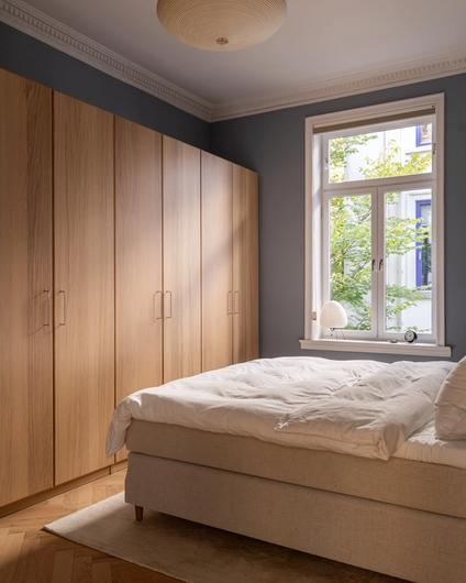 Nyoppusset soverom med fiskebensparkett fra Skogr, dobbeltseng, skap fra Ikea og taklampe fra Vitra. Utført av Lomundal.