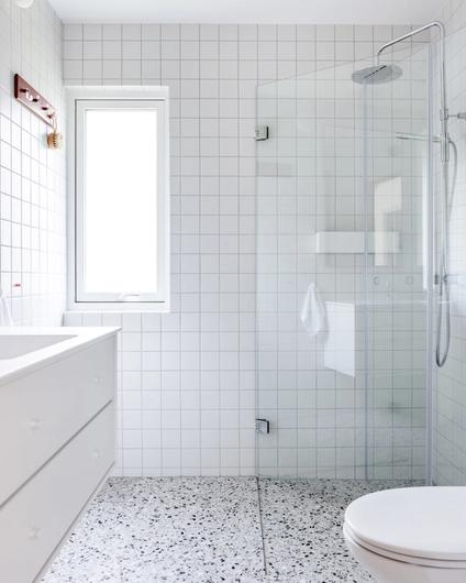 Retro bad med lys terrazzo flis på gulv og hvite kvadratiske fliser på vegg. Armaturer i krom og hvit baderomsinnredning fra Montana.