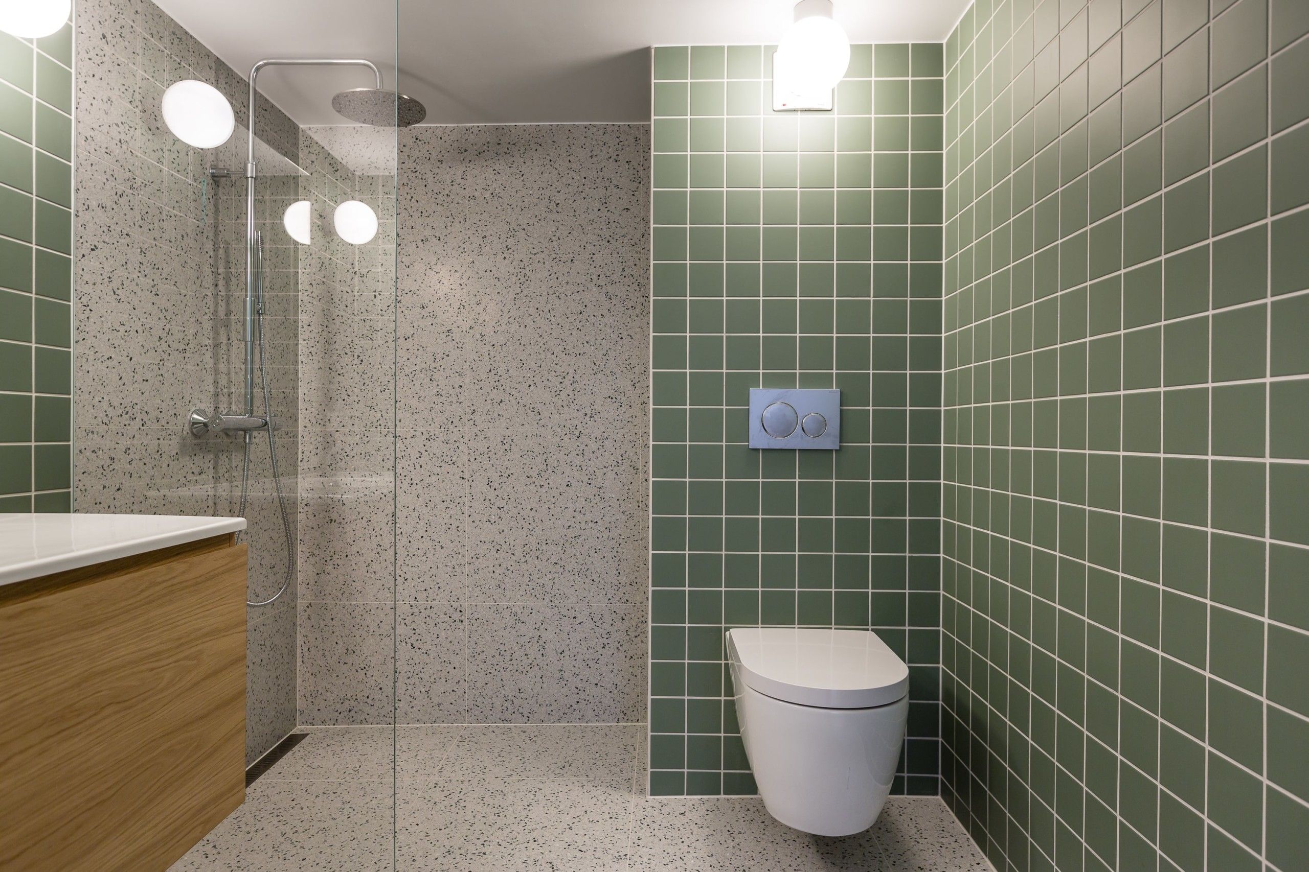 Retro bad med grønne fliser på vegg, fliser med terrazzo på gulv og dusjrom, utført av Lomundal.